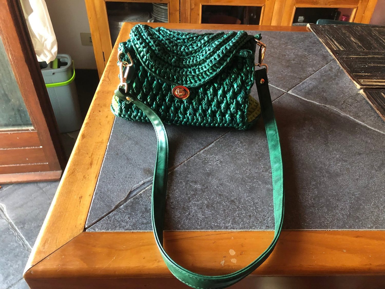 Borsa verde con patta lavorata a onda e tracolla liscia, vista davanti